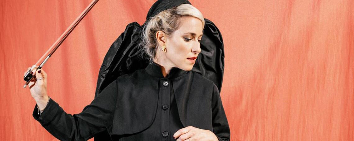 Julia Lacherstorfer mit Kopftuch, schwarzem Kleid und Geigenbogen